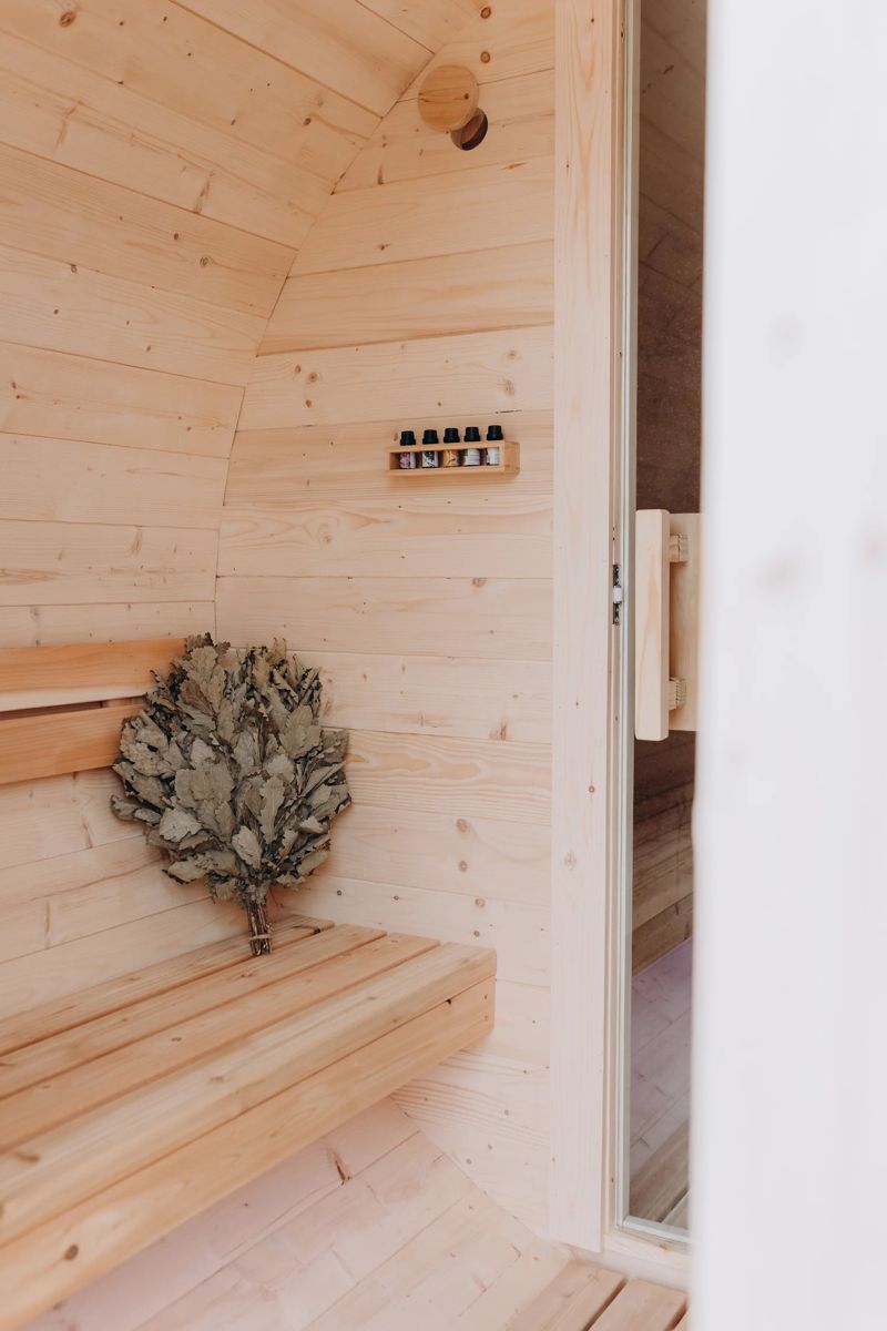 Cedar sauna bench with a leafy sauna whisk resting on it