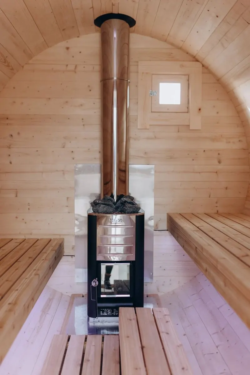 Wood-burning sauna stove between two cedar benches